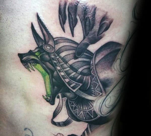 anubis with glowing green mouth mens ribcage tattoos