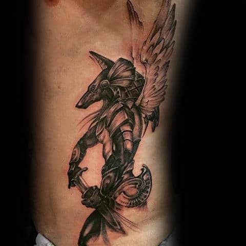 anubis with sword and wings male rib cage tattoos