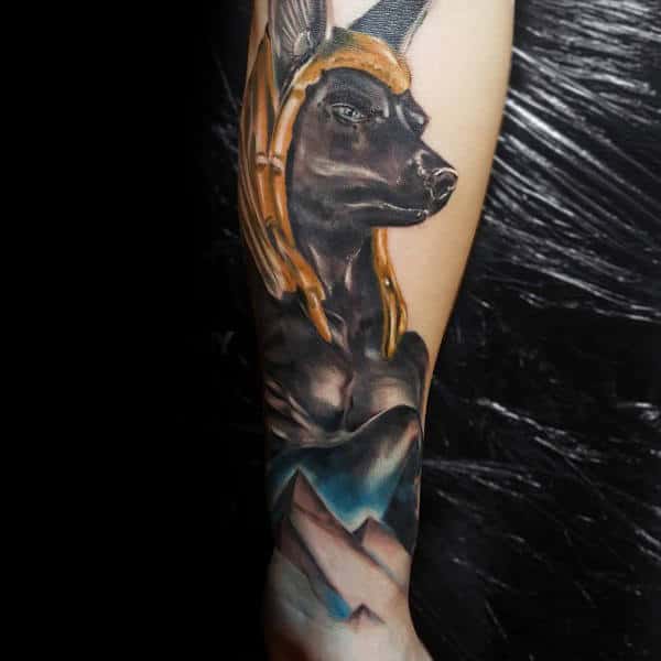 masculine anubis watercolor male tattoo on forearm