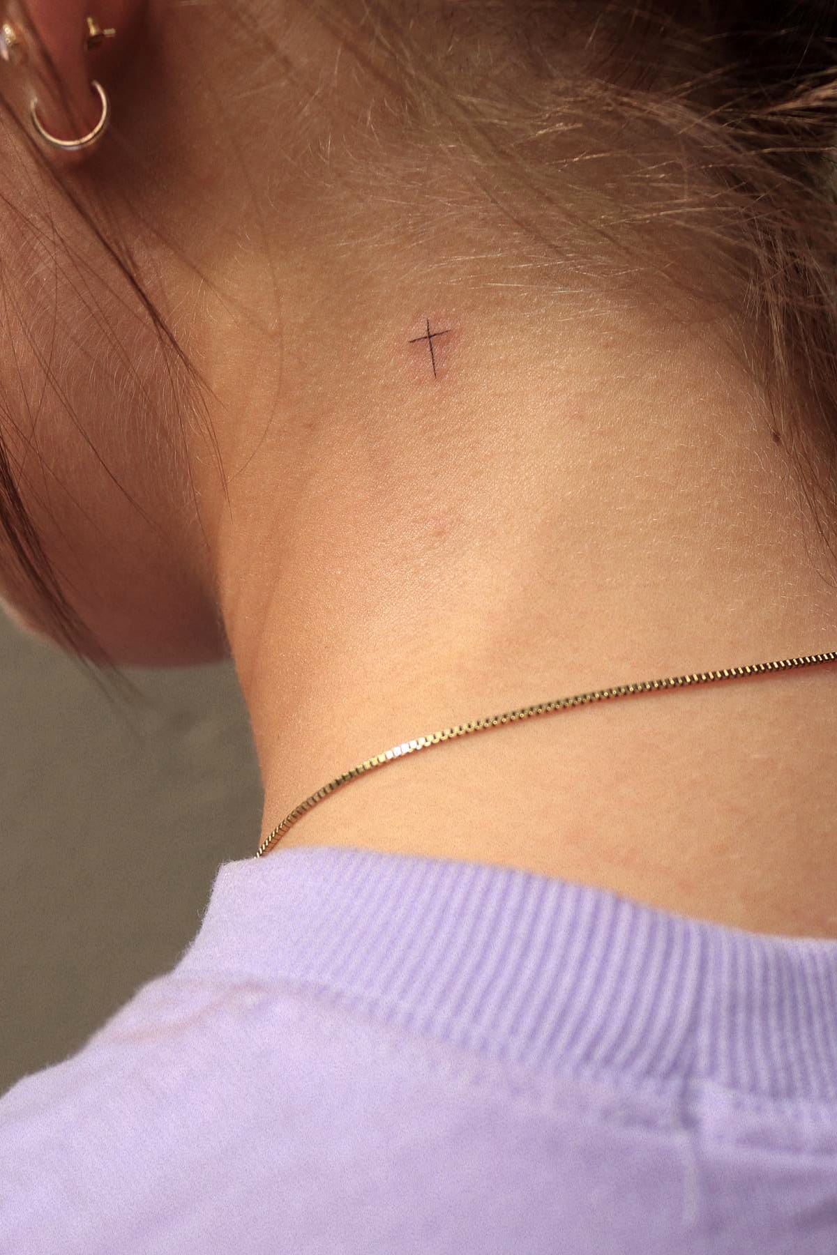 Small cross tattoo on neck