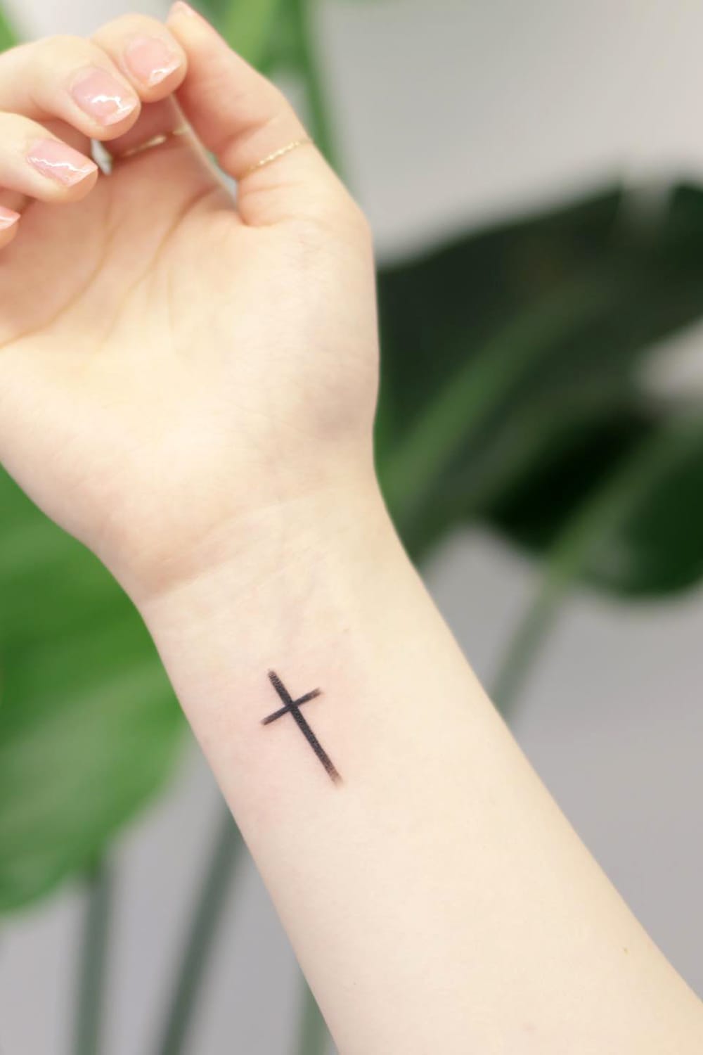 Small cross tattoo on wrist