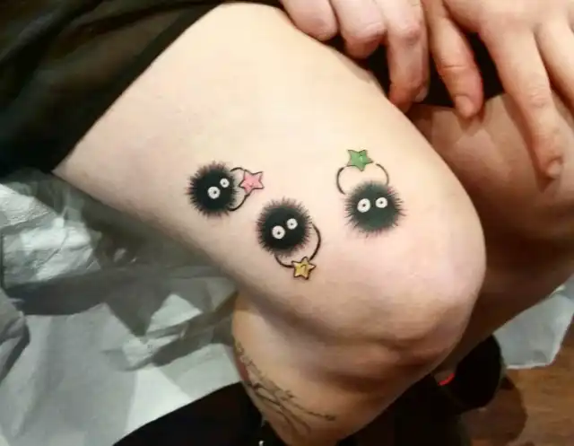 Soot sprite with stars tattoo on lower thigh