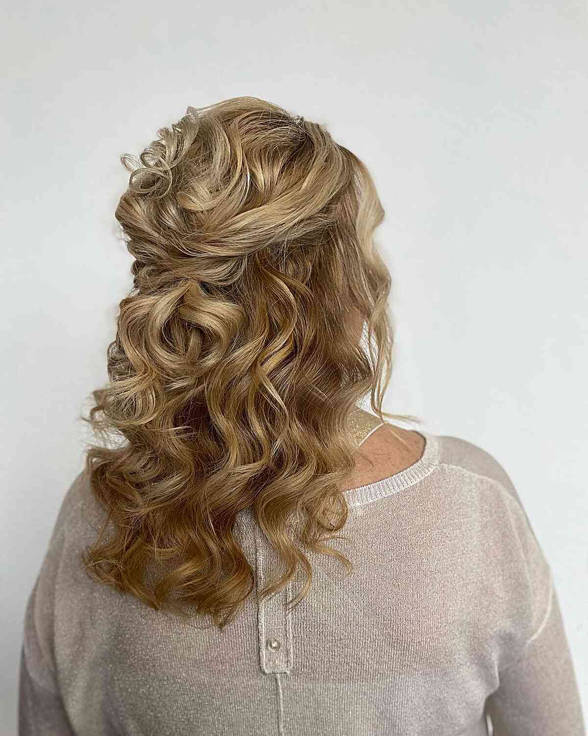 formal overlap half up with loose curls for wedding guests