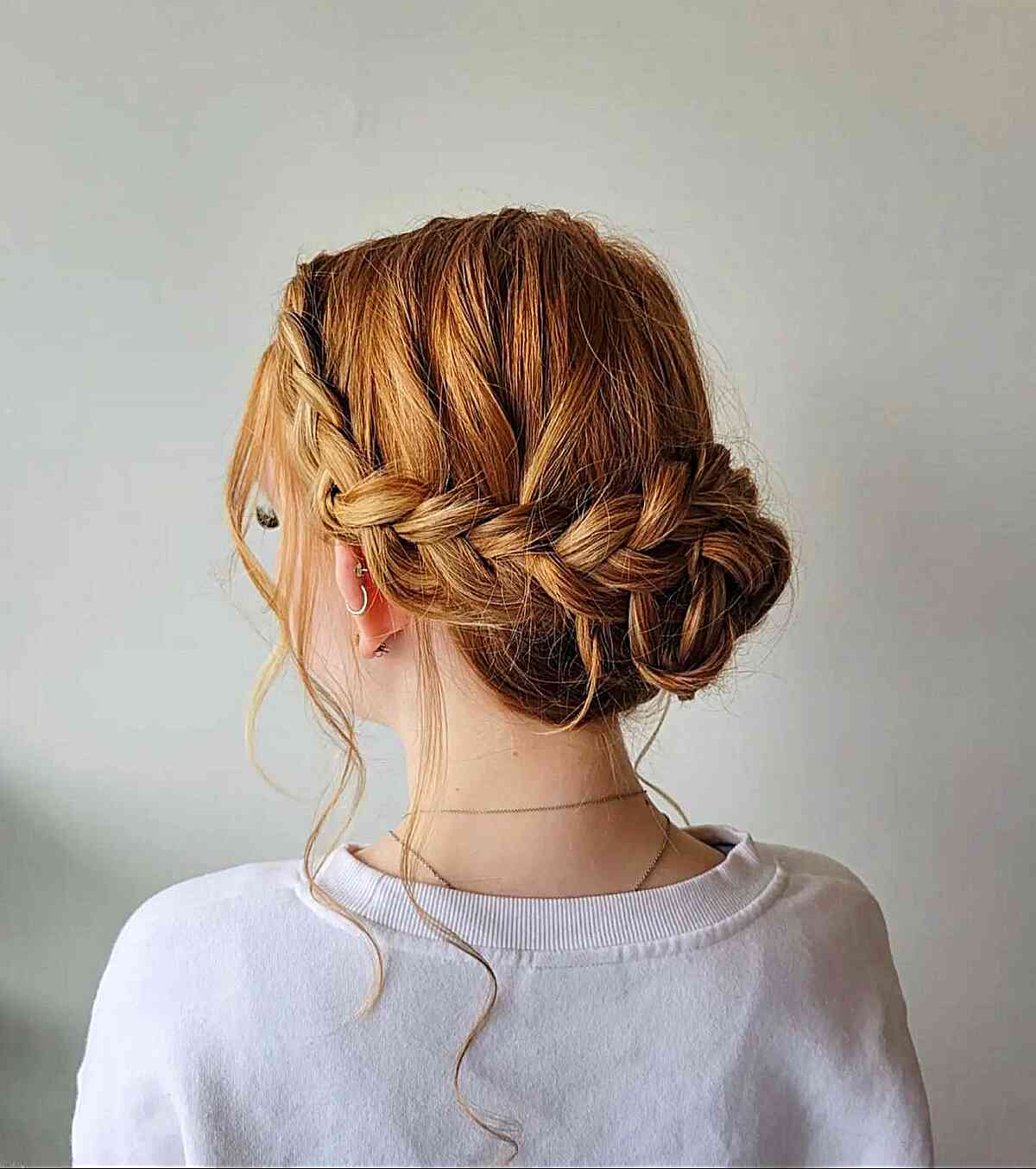 low braided bun with loose strands for graduation
